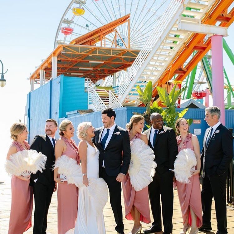 Bride, groom, and wedding party on the Santa Monica Pier