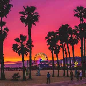 A view of an orange and pink sunset be the Santa Monica Oier | Photo by @thatislandview