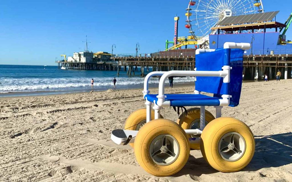 Beach wheelchair on sand in front of the Santa Monica Pier