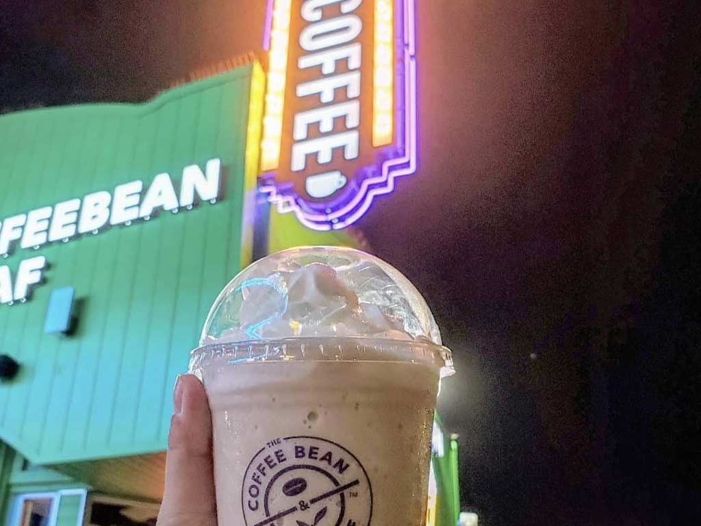 Ice blended drink in front of coffee sign