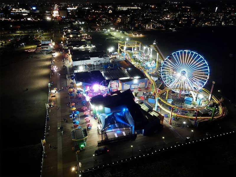 Images of drumsticks cascade accross the face of the Pacific Wheel at Pacific Park | Photo by @possuelo