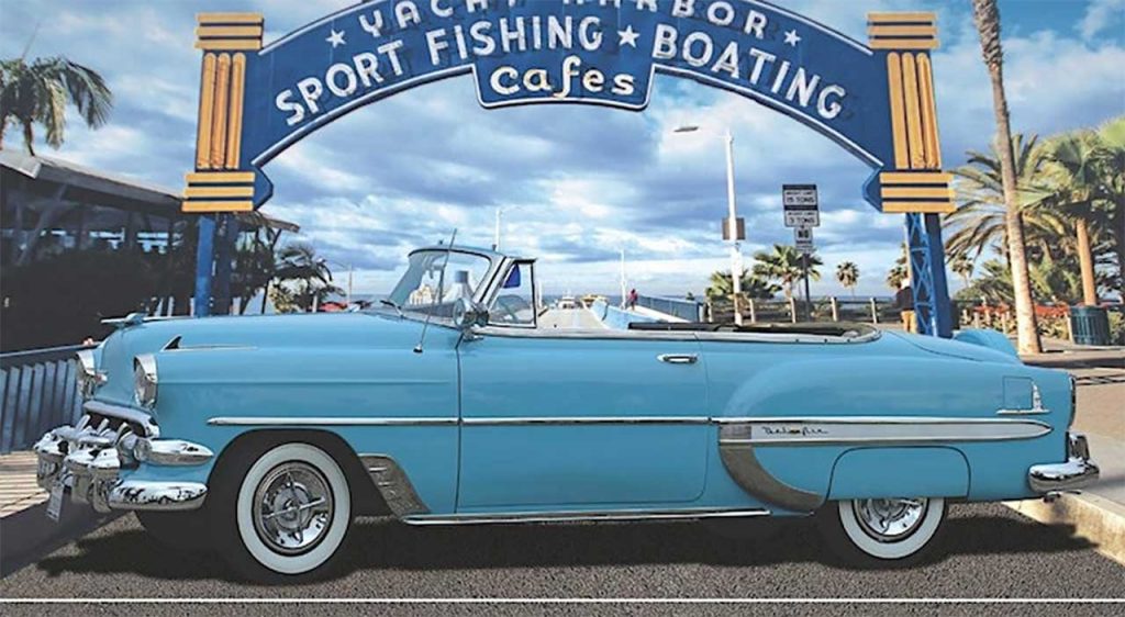 A classic car parked in front of the Santa Monica Pier's famous "Yacht Harbor" sign