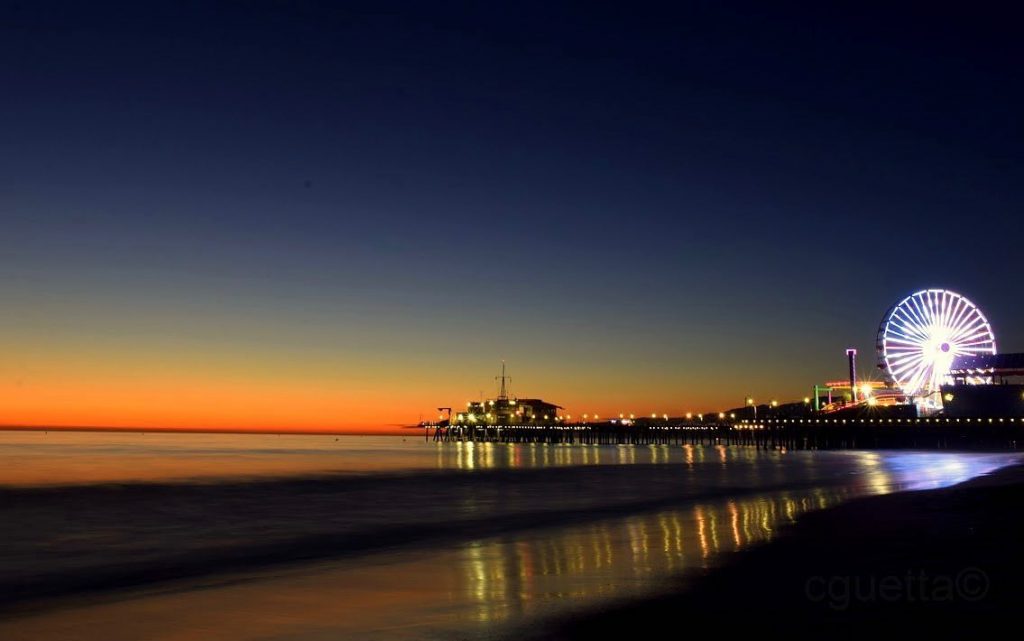 The Pacific Wheel lit in red, white, and blue for Veterans Day at dusk as seen from the beach south of the Santa Monica Pier | photo by @_cguetta